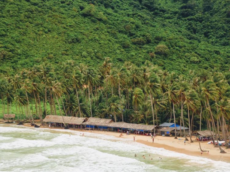 Turquoise sea and coconut trees along Nam Du Islands beach