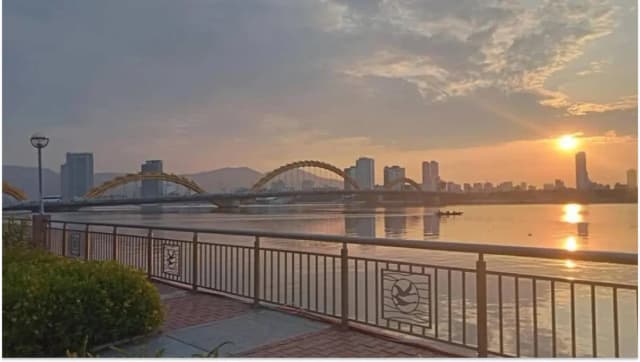 Dragon Bridge in Da Nang glowing under the sunrise
