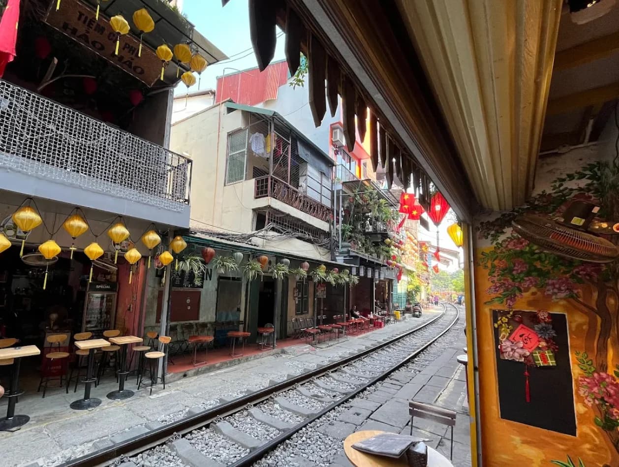 Vibrant street life with locals and cafes along train tracks
