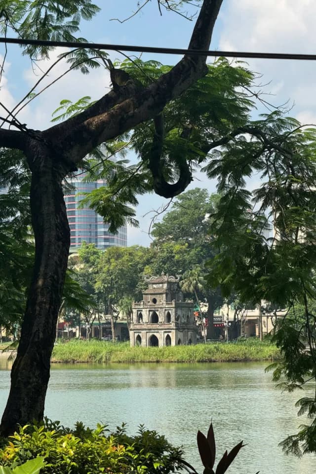 Peaceful view of Turtle Tower surrounded by old trees on Hoan Kiem Lake