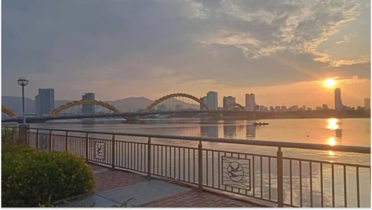 Dragon Bridge in Da Nang glowing under the sunrise