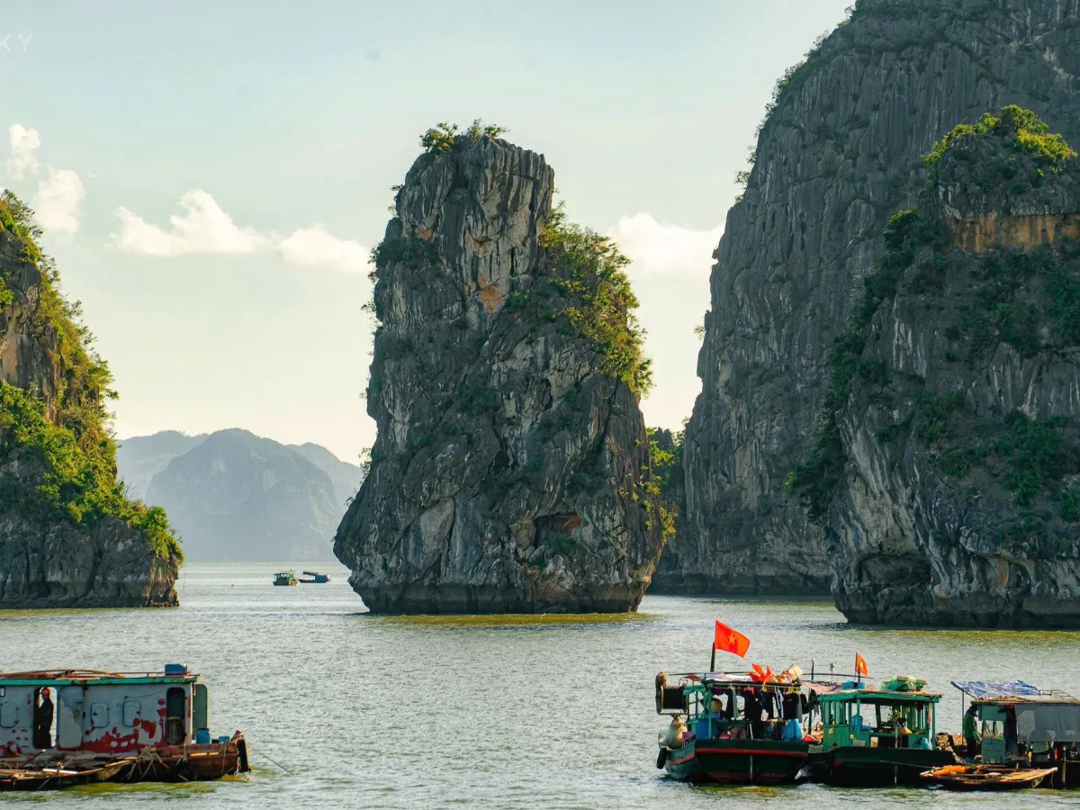 Boat sailing among limestone mountains in Ha Long Bay