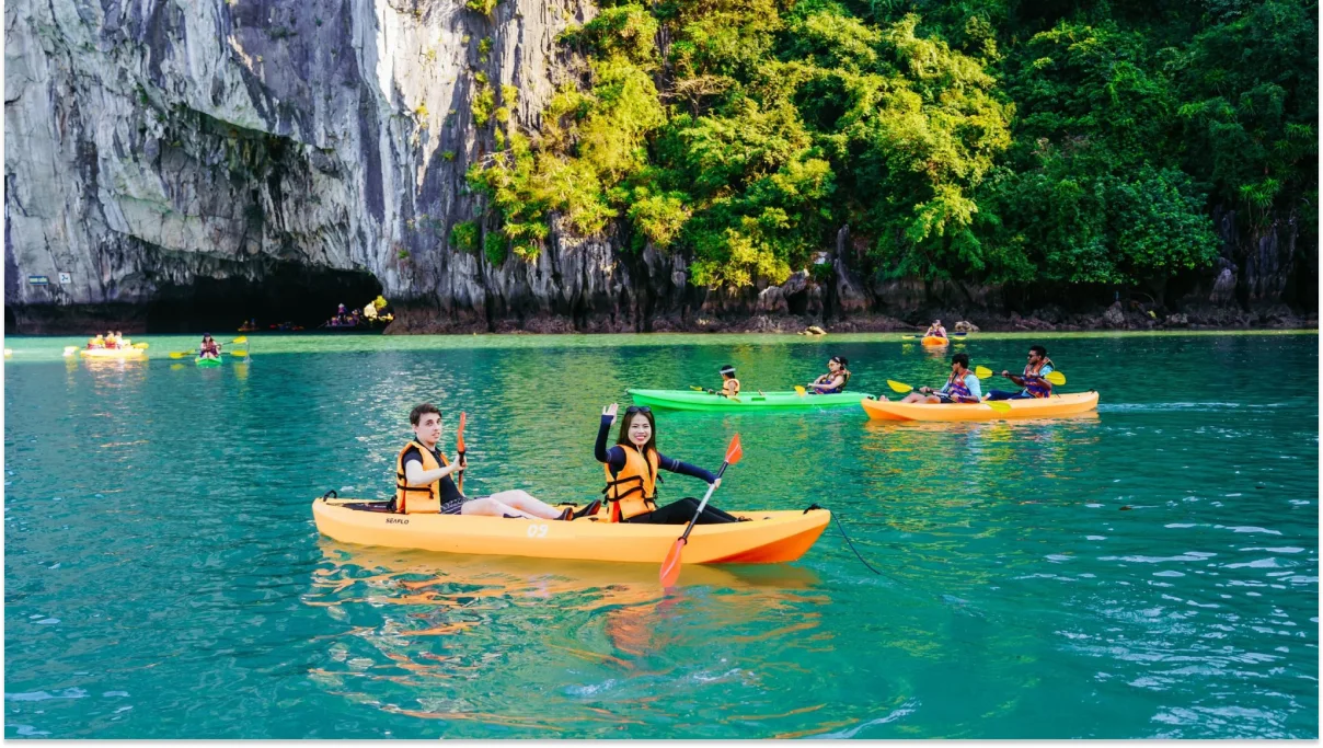 Tourists kayaking between limestone mountains in Ha Long Bay